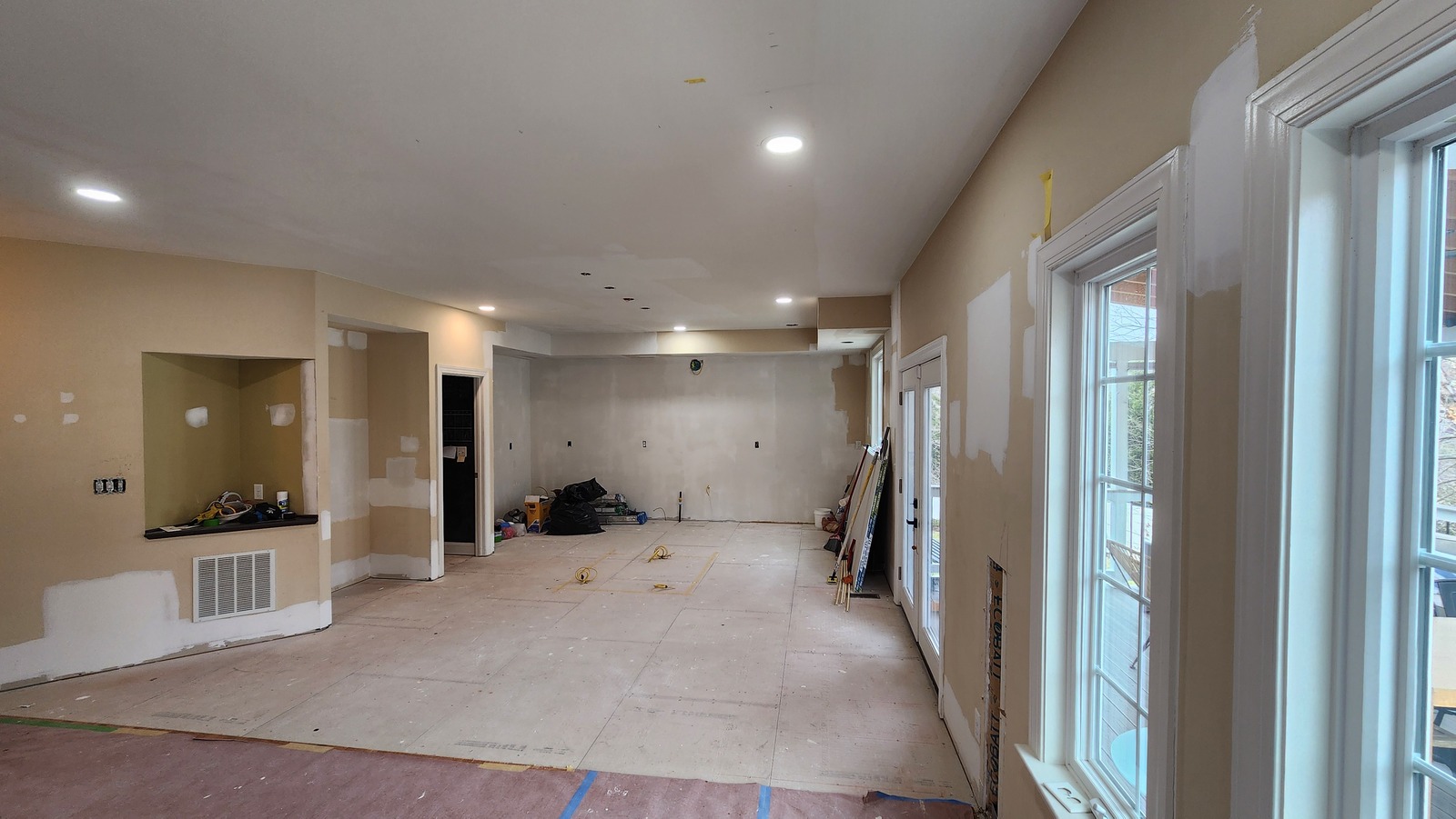 Interior work in progress with patched walls and ceiling and protective coverings on the floor